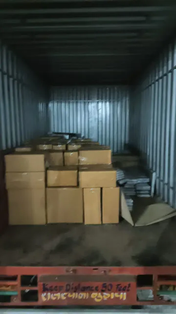 Cartons grouped inside the rear of a covered cargo container.