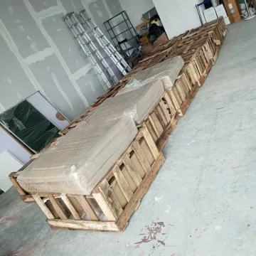 Long wrapped pieces supported by wooden crate frames.