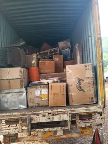 Cartons and wrapped household pieces arranged inside a cargo vehicle.