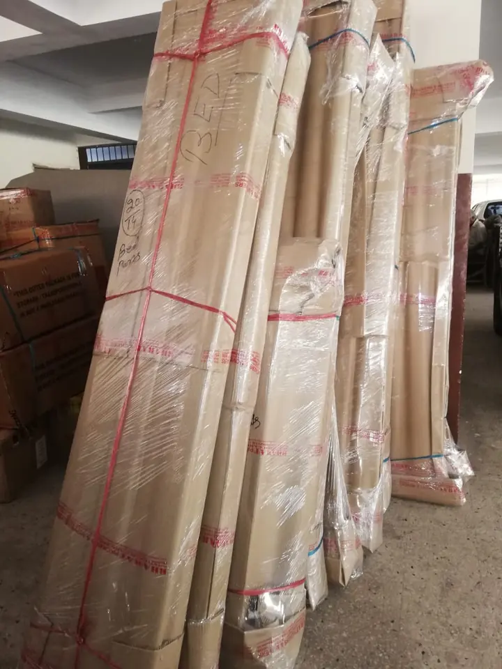 Several tall furniture panels wrapped individually and secured with coloured straps.