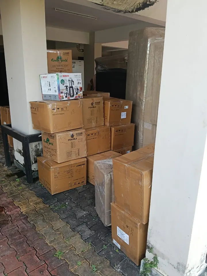 Labelled cardboard cartons grouped beside a doorway inside a home.