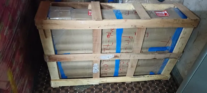 A rectangular wooden crate with blue inner covering positioned inside a cargo vehicle.