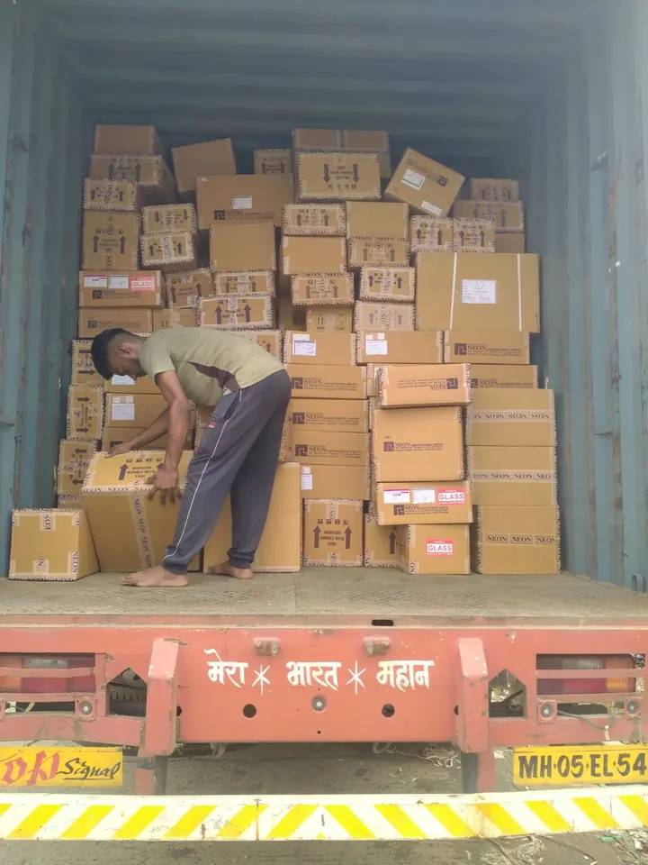 Many sealed cartons stacked inside an enclosed cargo vehicle.