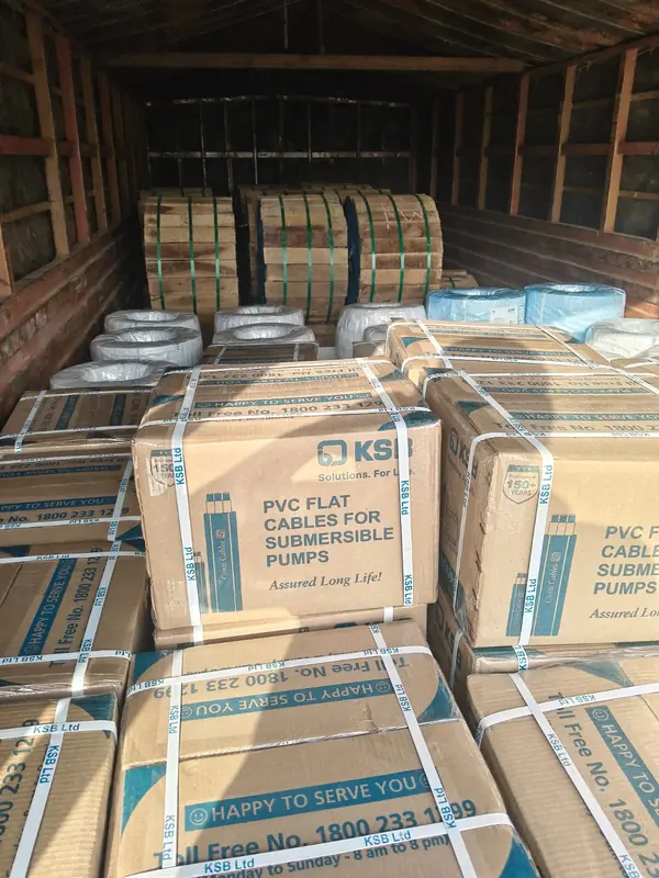 Cartons and wooden-framed packages secured with straps inside a cargo container.