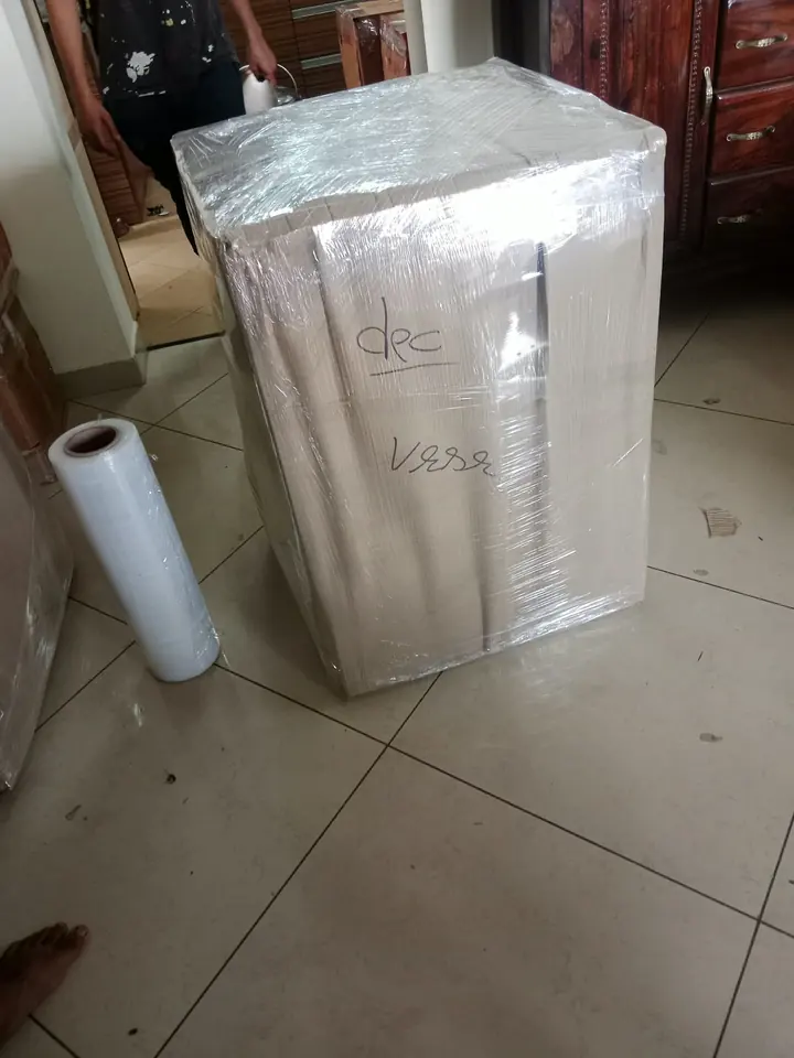 A compact box-shaped household unit covered with protective wrapping.