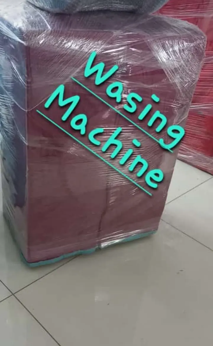 A washing machine covered in protective material with a handwritten item description on the image.
