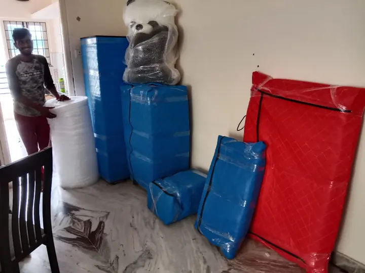 Blue and red wrapped household pieces grouped inside a room.