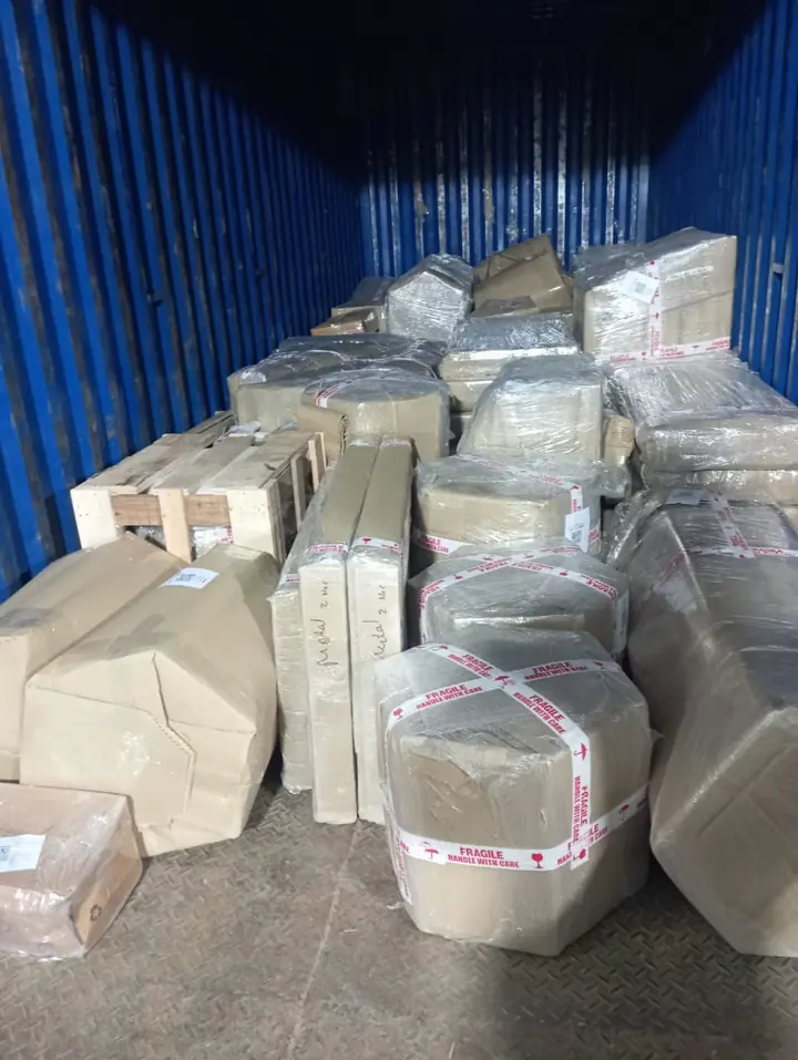 Wrapped household packages of different shapes arranged inside a cargo container.