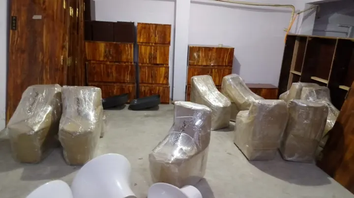 Wrapped furniture pieces grouped inside a room.