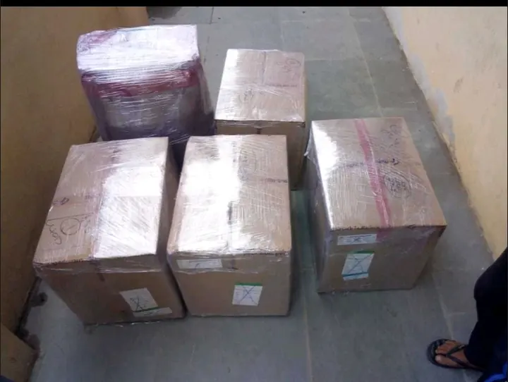 Five wrapped household packages grouped together on a tiled floor.