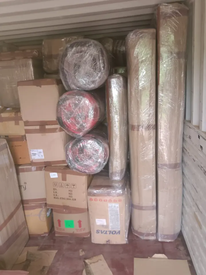 Wrapped cylindrical pieces, long rectangular packages and cartons inside a container.