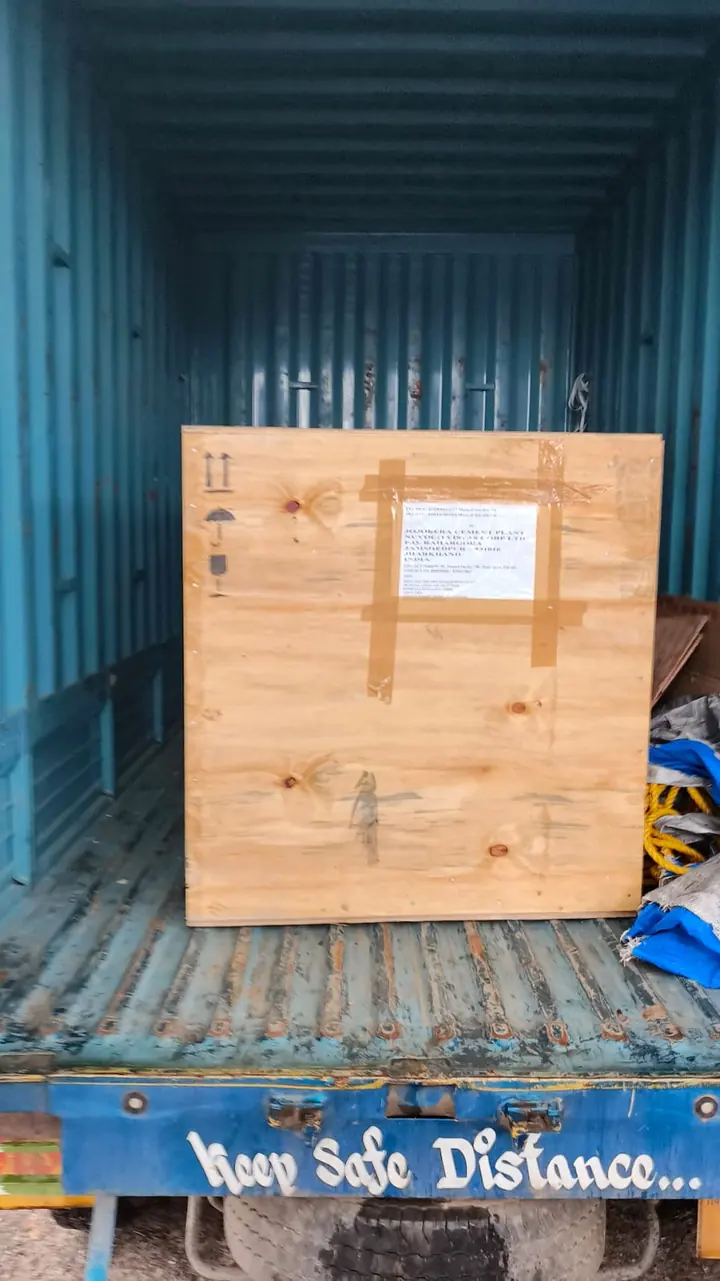 A large closed wooden crate positioned inside a blue cargo vehicle.