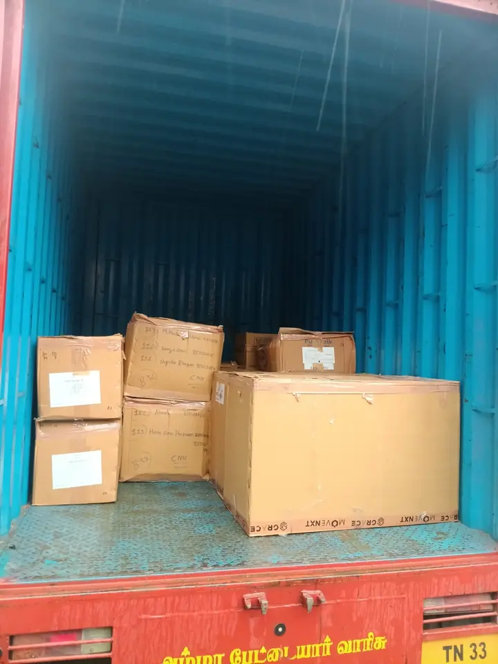 A small group of cartons placed inside a blue cargo container.