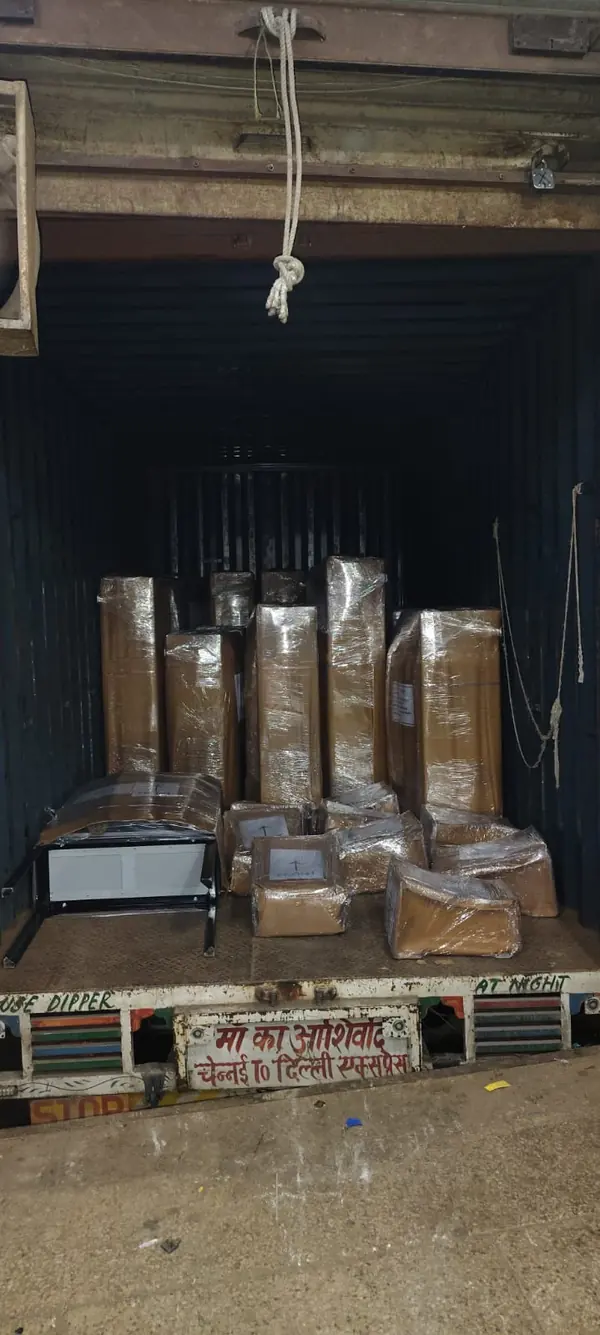 Several upright wrapped packages and smaller pieces grouped inside a cargo vehicle.