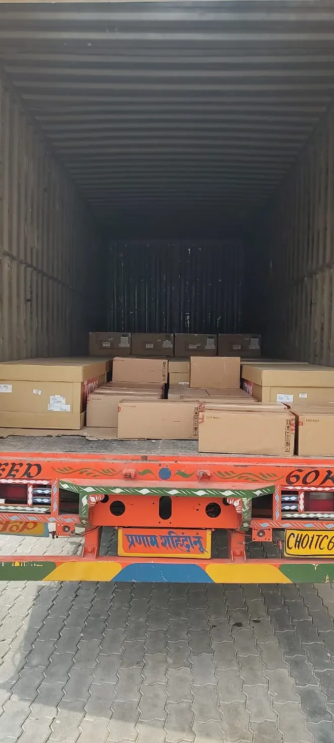A small group of cartons positioned on the floor of a large enclosed vehicle.