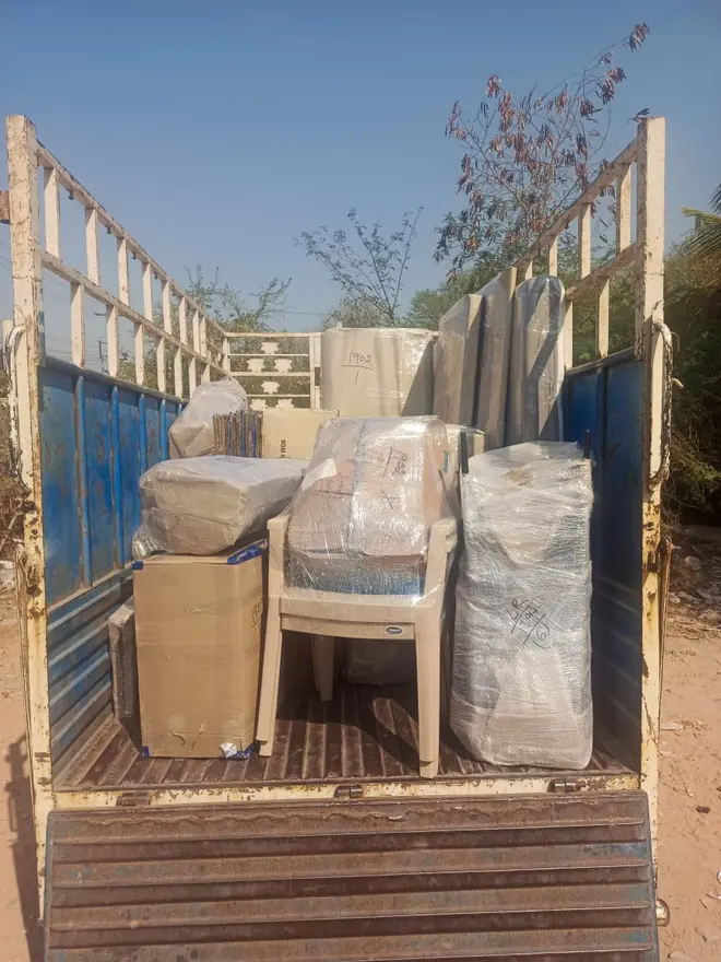 Wrapped seating and other upright household packages arranged in a goods vehicle.