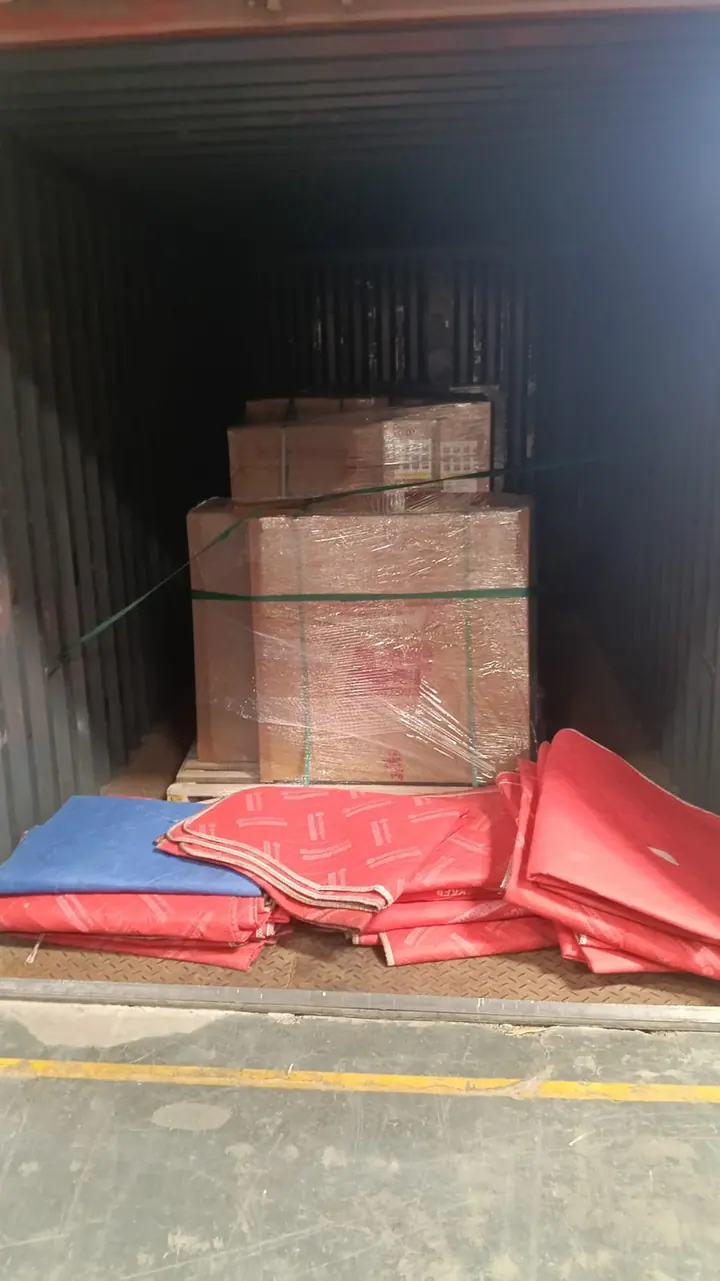 Packed goods inside a container, with red protective material lying nearby.